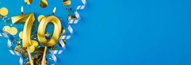 70 yıllık kutlama. 70 numaralı altın yanan mumlar mavi arka planda konfetili, kopyalama alanı. Selamlama pankartı.