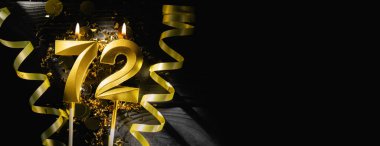 72 numaralı altın mum, 72. yaş gününü kutlarken parlak bir şekilde yanıyor. Siyah arka planda şenlikli kurdeleler ve konfeti zarif bir kutlama bayrağı oluşturuyor. Boşluğu kopyala.