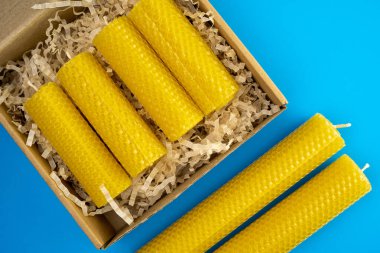 Balmumu mumları mavi arka planda bir el işi kutusunda paketlenmişti. Üst görünüm.