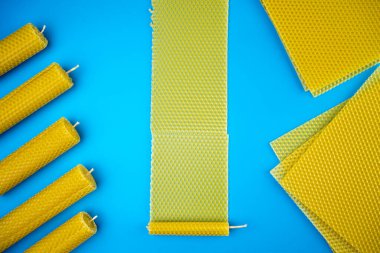 Mavi arka planda balmumu mumları ve balmumu çarşaflar. Balmumu yapma işlemi. Üst Manzara. Düz yatıyordu