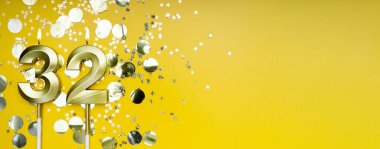 Sarı arka planda 32 numaralı altın mum. 32 harfli doğum günü kartı. Yıldönümü konsepti. Doğum günü, yeni yıl kutlaması için. Banner, boşluğu kopyala.