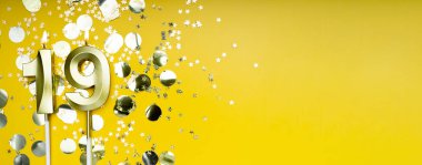 Sarı arka planda 19 numaralı altın mum. 19 harfli doğum günü kartı. Yıldönümü konsepti. Doğum günü, yeni yıl kutlaması için. Banner, boşluğu kopyala.