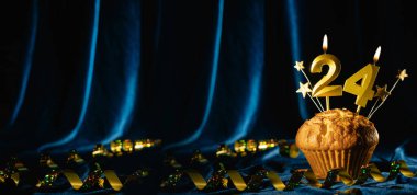 24 'üncü yaş günü partisi yaklaşıyor. Kadife mavisi arka planda 24 numaralı mumu olan çikolatalı kek. Pankart, metin için boşluk.
