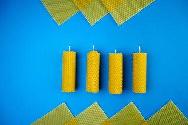 Balmumu mumlar, mavi arka planda gözenekli balmumu çarşaflar. Yaratıcı meslek kavramı, küçük işletmelerin el yapımı sanatı, çevre dostu tasarım.