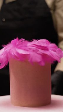 Şekerci, kürsüde pembe tüylerle süslenmiş pembe pastayı çeviriyor, fırın sanatını ve pasta üretim konseptini gözler önüne seriyor, canlı zarafeti yaratıcı tatlı zanaatkarlığıyla harmanlıyor.