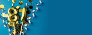 81 yıllık kutlama. Mavi arka planda konfetili 81 numaranın altın yanan mumları, kopyalama alanı. Selamlama pankartı.