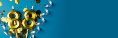 88 yıllık kutlama. Seksen sekiz numaralı altın yanan mumlar mavi arkaplanda konfeti ile, kopyalama alanı. Selamlama pankartı.