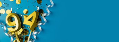 94 yıllık kutlama. Mavi arka planda, konfetili 94 numaralı altın yanan mumlar, kopyalama alanı. Selamlama pankartı.