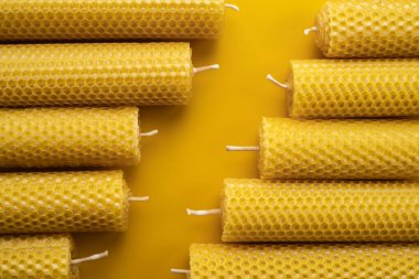 Sarı arka planda balmumundan yapılmış sarı eko mumlar. Yakın plan.