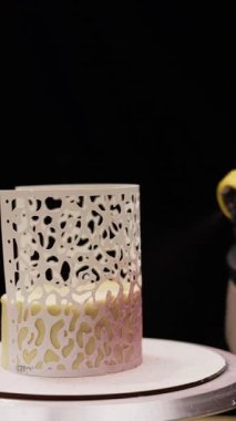 Pasta şefinin yakın plan çekimleri lezzetli pastaları şekerleme fırçasıyla süslemesi zebra desenli kalıplar kullanarak tatlı yüzeyindeki yaratıcı ve detaylı tasarım için yenilebilir boya uygulaması..