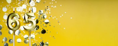 Altmış beş yıllık doğum günü. 65 numaralı altın kutlama mumu. Sarı renkli arka plan. Doğum günü ya da yıldönümü kutlaması kavramı. Pankart. Boşluğu kopyala