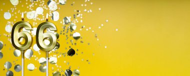 Altmış altı yıllık doğum günü. 66 numaralı altın kutlama mumu. Sarı renkli arka plan. Doğum günü ya da yıldönümü kutlaması kavramı. Pankart. Boşluğu kopyala