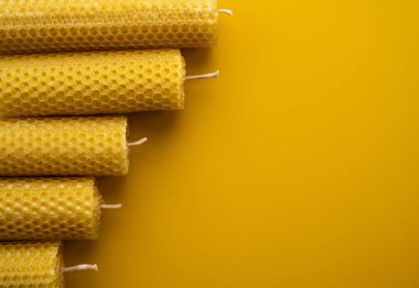 Sarı arka planda balmumundan yapılmış sarı eko mumlar. Yakın plan.