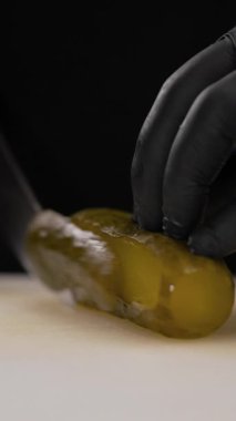 Şefler mutfakta salata için sebze ve sağlıklı yemek için organik sebze hazırlıyorlar. Salatalık turşusu kesen adam, yakın plan.