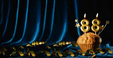 88 numaralı kutlama mumu ve parlak mavi kadife arka planda tatlı kek içinde küçük yıldızlar. Doğum günü ve yıldönümü kutlaması kavramı. Pankart. Boşluğu kopyala.