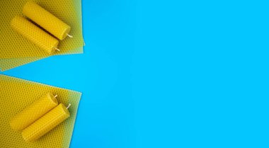 Doğal ekolojik ev dekorasyonu kavramı. Mavi arka planda balmumu çarşaflı aroma mumları. Düz yatıyordu