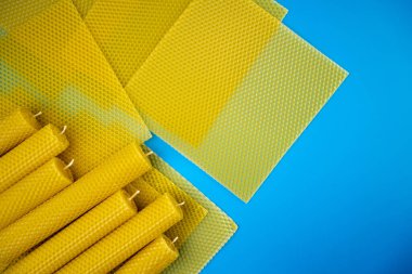 Balmumu mumu. Dekoratif balmumu mumlar ve balmumu çarşaflar mavi arka planda, düz yatış, üst manzara