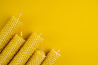 Sarı arka plana yerleştirilmiş balmumu mumları. Düz Yat. Boşluğu kopyala