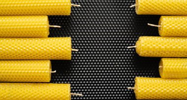 Sarı el yapımı mumlar siyah balmumu desenli arka planda bir çerçeve oluşturuyor. Boşluğu kopyala