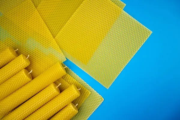 Balmumu mumu. Dekoratif balmumu mumlar ve balmumu çarşaflar mavi arka planda, düz yatış, üst manzara