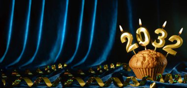 Mavi kadife arka planda altın mumlarla süslenmiş yeni yıl keki. Mutlu yıllar 2032. Kış tatili geçmişi. Pankart. Boşluğu kopyala