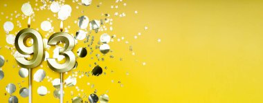 Doksan üç yıllık doğum günü. 93 numaralı altın kutlama mumu. Sarı renkli arka plan. Doğum günü ya da yıldönümü kutlaması kavramı. Pankart. Boşluğu kopyala.