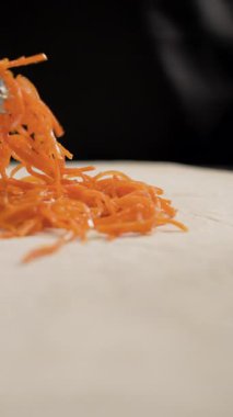 Fast food kafesinde ya da sokak yemeklerinde et şavurması hazırlarken Kore havucunu lavaşın üzerine koyan şefin yakın çekimi. Adım adım shawarma tarifi. Yakın plan.
