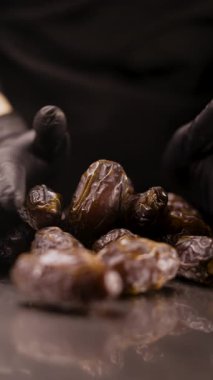Sağlıklı bir tatlı hazırlamak için bir avuç dolusu kurutulmuş hurma toplayan şekerci elleri. Hamur işi, şekerleme ve vejetaryen tatlıları kavramı..