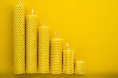 Balmumu mumları, azalan bir eğilimi sembolize etmek için aşağı doğru sıralanır. Tasarım, genel olarak piyasa düşüşleriyle ilişkili olarak, düşüşü temsil etmektedir.