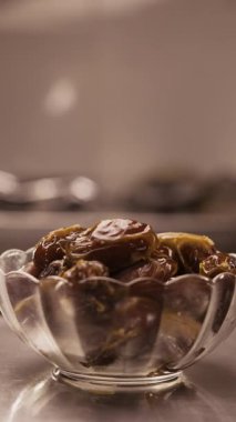 Birbirine girmiş kat kat tomurcukları olan cam bir kaseye yaslanırlar. Bir el bir parça almak için kaseye uzanıyor. Parlak dokuya ve doğal renge odaklan.