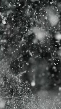 Siyah arka planda kar, karlı soyut doku, düşen kar taneleri, kış fırtınası. Yavaş çekim