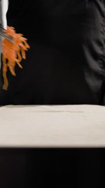 Siyah eldivenli şef fast-food restoranında et yemeği yapmak için lahanaya Kore havuç salatası koyar. İşlem aşçılık hazırlama tekniklerini gösterir.