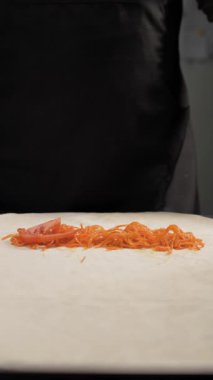 Adım adım shawarma tarifi. Şef taze domates dilimlerini ince lavaşın üzerine koyarak sokak yemekleri yapıyor. Lezzetli fast food malzemeleri topluyor..