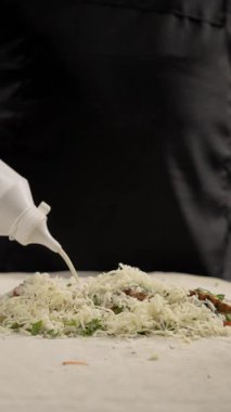 Adım adım shawarma tarifi. Baharatlı et ve taze sebzelerin üzerine serpiştirilmiş mayonez serpiştirilmiş şefin yakın çekimi. Fast food ve Türk mutfağı kavramı. Dikey video