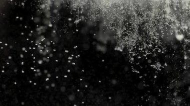 Kar taneciklerinin yavaş çekimde yaklaşması gecenin karanlığında yavaşça düşerek rüya gibi bir kış atmosferi yaratıyor. Narin donmuş kristaller hareket halinde olan soyut karlı arkaplan.