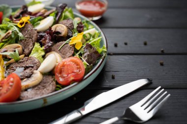 Renkli ızgara sebze salatası, taze sığır eti şeritleri, mantarlar, yapraklı yeşiller, yumurta parçaları ve balzamik sirke. Besleyici ev yapımı yemek fikri. Doğal ışık arkaplanı.