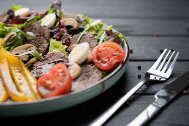 Izgara biberli taze sebze salatası, sıcak sığır eti dilimleri, mantarlar, balzamik jöle, marul ve beyaz tabakta haşlanmış yumurta. Sağlıklı yemek konsepti. Üst görünüm.