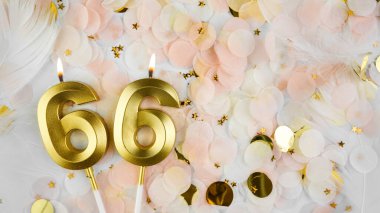 66. yaş günü kartı. 66 numaralı altın mum. Pastel konfeti arka planında 66 numara. Yıldönümünü ve doğum gününü kutluyoruz. Boşluğu kopyala.