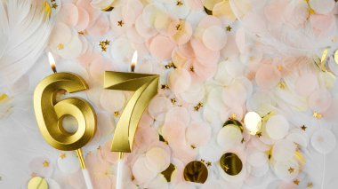 67. yaş günü kartı. 67 numaralı altın mum. Pastel konfeti arka planında 67 numara. Yıldönümünü ve doğum gününü kutluyoruz. Boşluğu kopyala.