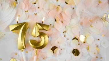 75. yaş günü kartı. 75 numaralı altın mumlar, pastel konfeti arka planında 75 'lik figür. Yıldönümünü ve doğum gününü kutluyoruz. Boşluğu kopyala.