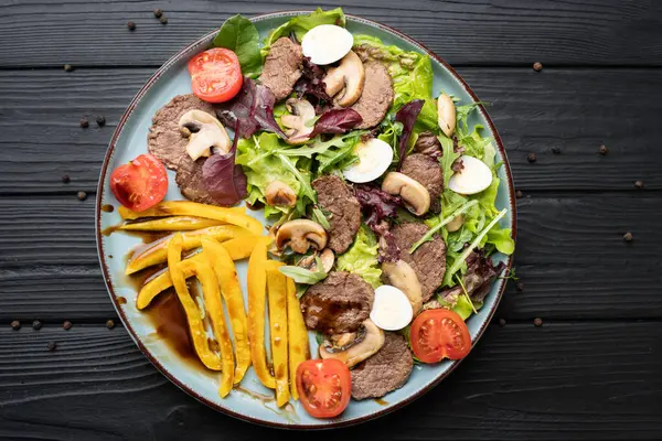 Sıcak dilimlenmiş sığır eti, mantar, ızgara biber, yumurta, marul ve balzamik sirke içeren bir tabak dolgun salata. Erdemli ve lezzetli yemekler. Genel bakış. Boşluğu kopyala