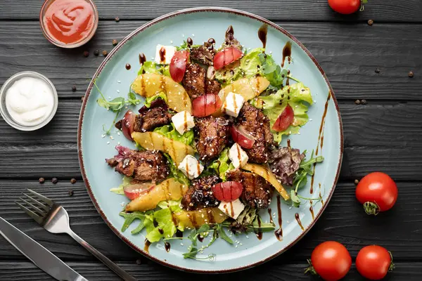 Kızarmış tavuk ciğeri, tatlı armut, taze üzüm, dorblu peynir, yeşillik ve bol balzamik sosla yapılmış lezzetli bir salata. Lezzetli ve sofistike restoran tarzı servis. Üst görünüm