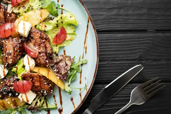 Karamelli armut, ızgara ciğer, gorgonzola peyniri, sulu üzüm, balzamik sirke ve taze yeşillik ile nefis bir salata. Zarif sunum. Güzel mutfak kavramı..