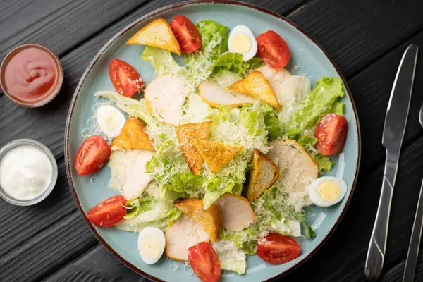 Taze tavuk dilimli ev yapımı Sezar salatası, çıtır kıtır ekmek, sulu domates, haşlanmış yumurta, romaine marulu ve dilimlenmiş peynir. Parlak aromalı klasik sağlıklı yemek. Üst görünüm