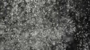 Hassas kar tanelerinin yavaş çekim makrosu yavaşça siyah zemine düşüyor, huzurlu gece atmosferini ve kış mevsiminin esansını güzel detaylarıyla yakalıyor..