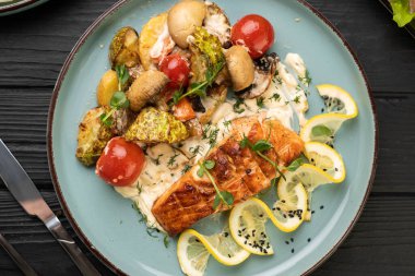 Lokantada ızgara sebzeli ve mantarlı haşlanmış somon balığı. Sağlıklı yemek, akşam yemeği için lezzetli yemek. Üst görünüm