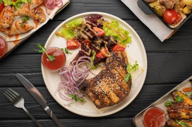 Mükemmel ızgara domuz eti, renkli sebze salatası, kiraz domatesleri ve soğan turşusuyla servis edilir. Lezzetli yemek ve lezzetli yemek kavramı. Üst görünüm