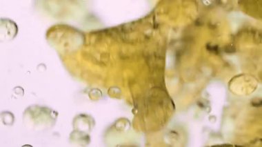 Yavaş Yağ Hareketi ve beyaz arka planda suda hava kabarcıkları. Köpüklü sıvı. Macro Shot. Yakın plan.