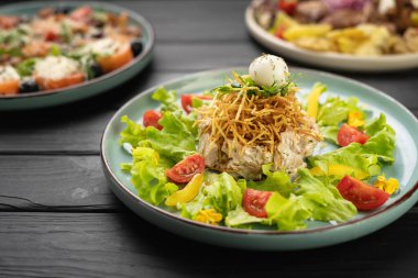 Tavuklu orman tavuğu yuvası salatası, kızarmış patates şeritleri ve masanın üstünde sebzelerle servis edilen bıldırcın yumurtası. Yakın plan.