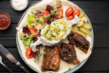 Fırında patates, sebze ve baharatlı ızgara domuz pirzolası. Yakın plan. Üst görünüm